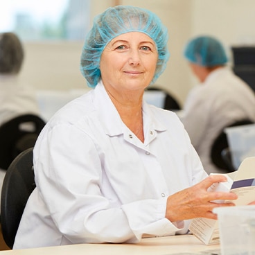 Frau packt Medikamente in Verpackung